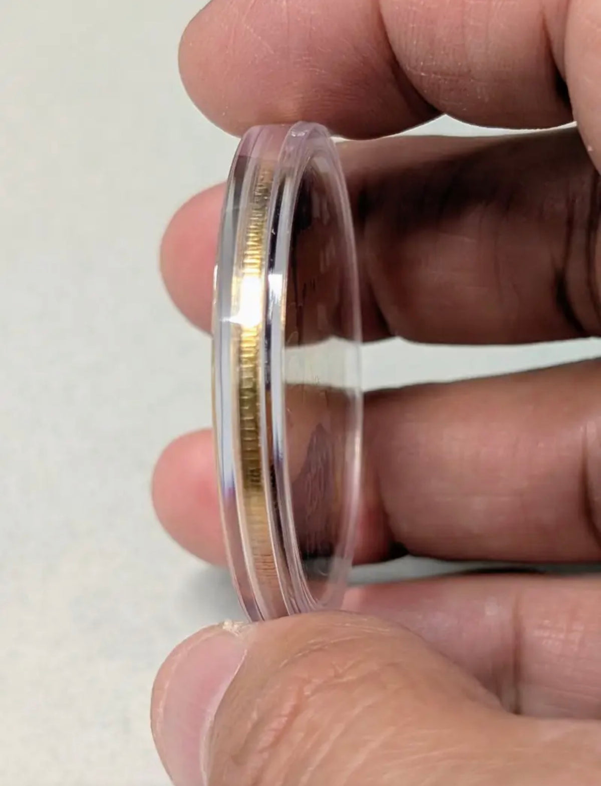 America 250 Challenge Coin side thickness shown held in fingers